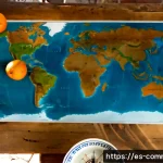 세계의 지도 - Photorealistic overhead view of a large unlabeled world map spread across a rustic wooden table in a...